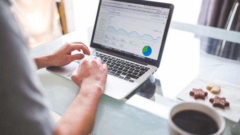 Person working on a laptop showing an analytics dashboard with growth charts