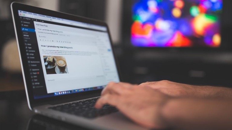 Person typing on a laptop with a product description draft open in an online editor