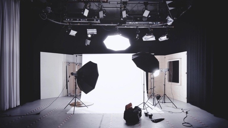 Professional photo studio with softbox lights and a white backdrop prepared for product photography