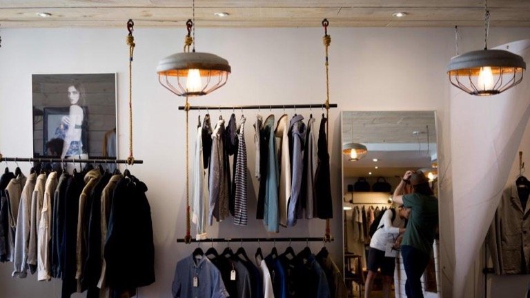 Bright clothing boutique with neatly displayed racks of clothes and accessories