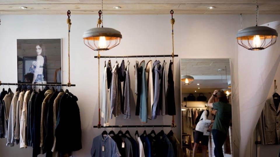 Bright clothing boutique with neatly displayed racks of clothes and accessories