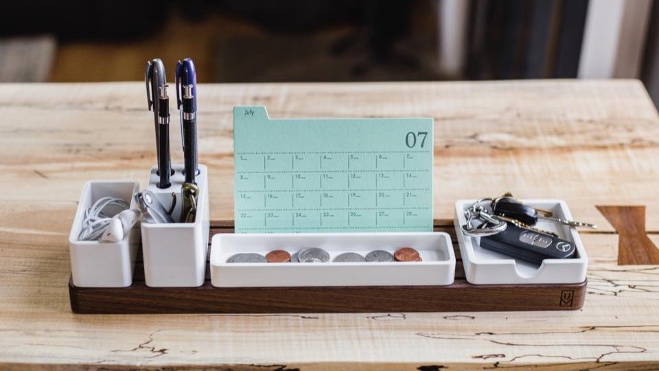 Desk organizer with a monthly calendar and pens, representing recurring subscription billing dates